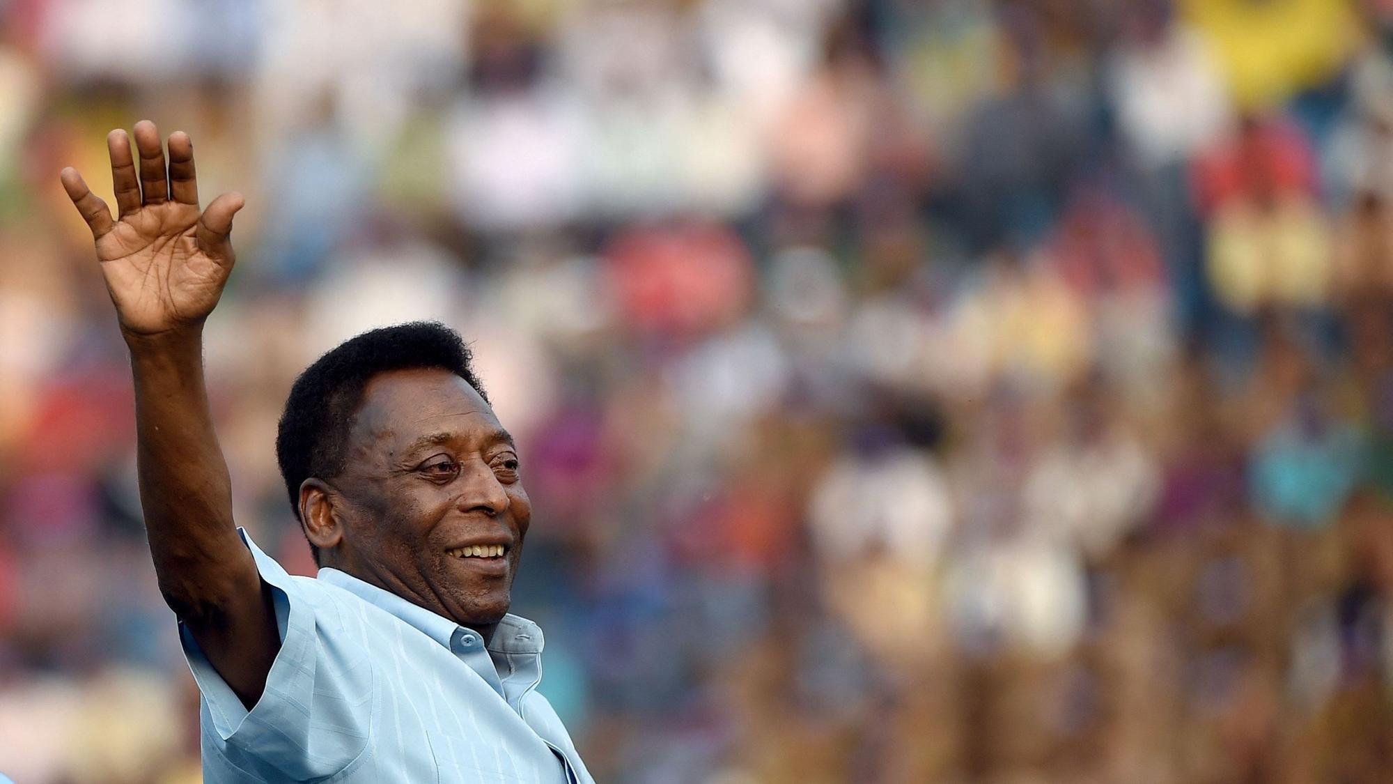 Fußball-Star Pelé winkt seinen Fans bei einem Spiel jugendlicher Fußballspieler zu.
