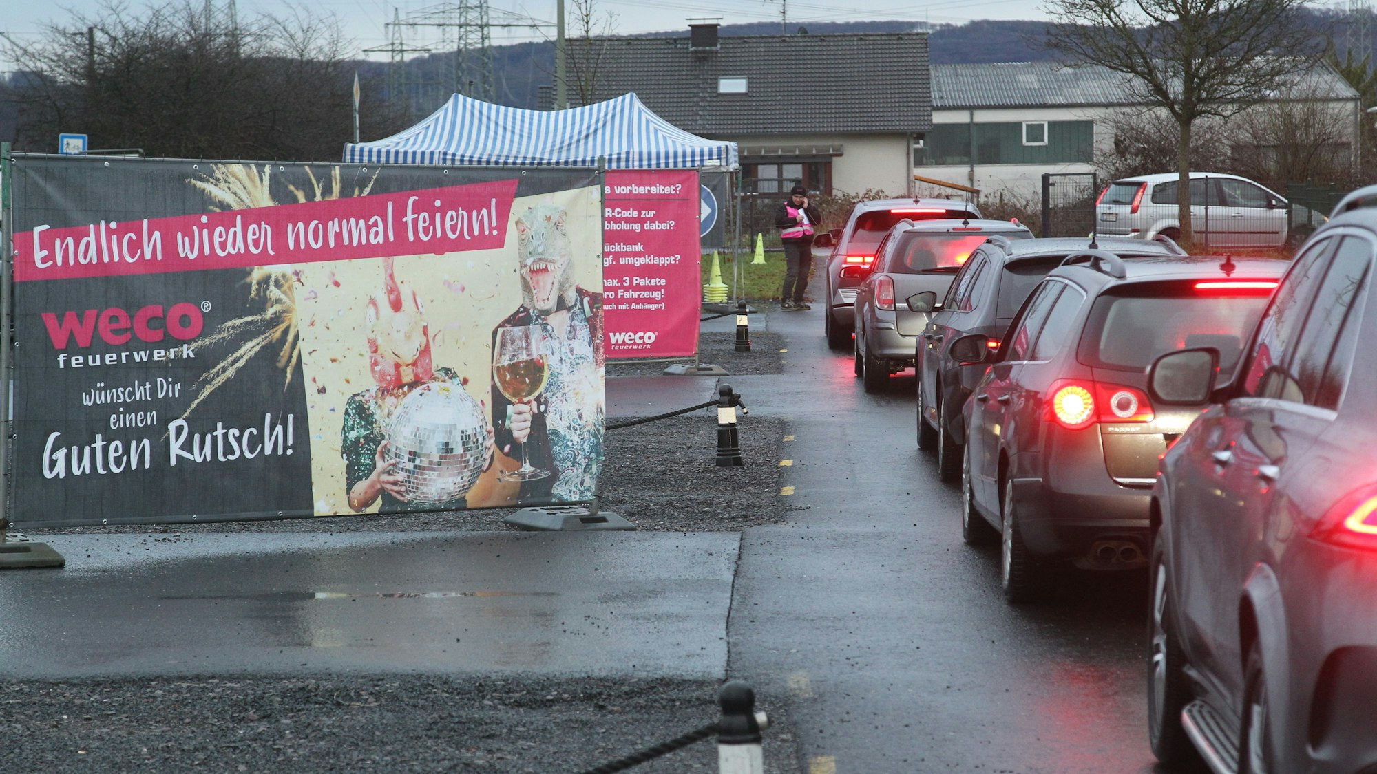 Eine Autoschlange neben einem Werbeplakat für Feuerwerk