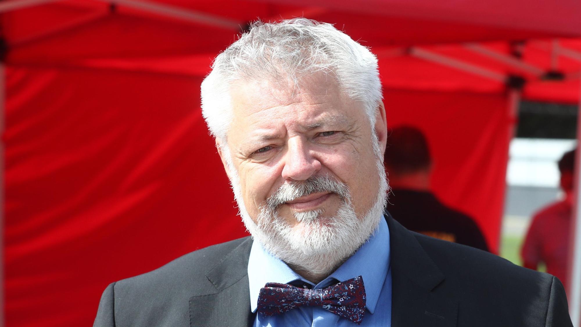 Prof. Dr. Alexander Michael Lechleuthner vor rotem Hintergrund.