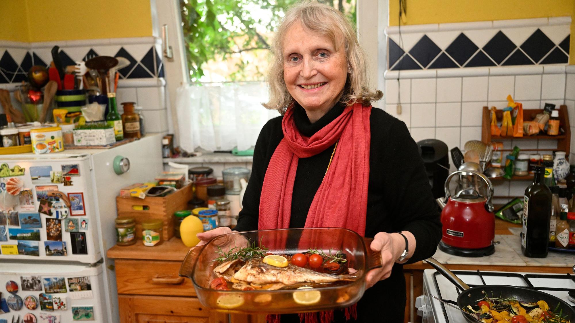 Renate Beisenherz-Galas hält eine Auflauffrom mit einer Dorade in ihren Händen.