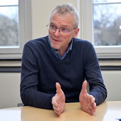 Bergisch Gladbachs Bürgermeister Frank Stein sitzt an einem Tisch und gestikuliert.