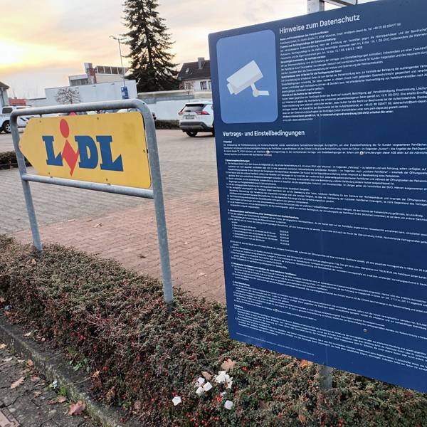 Ein großes, blaues Schild mit sehr langem, kleingedrucken Text steht an der Einfahrt zum Lidl-Parkplatz in Lohmar. Hier wird über Datenschutz, Vertrags- und Einstellbedingungen informiert.
