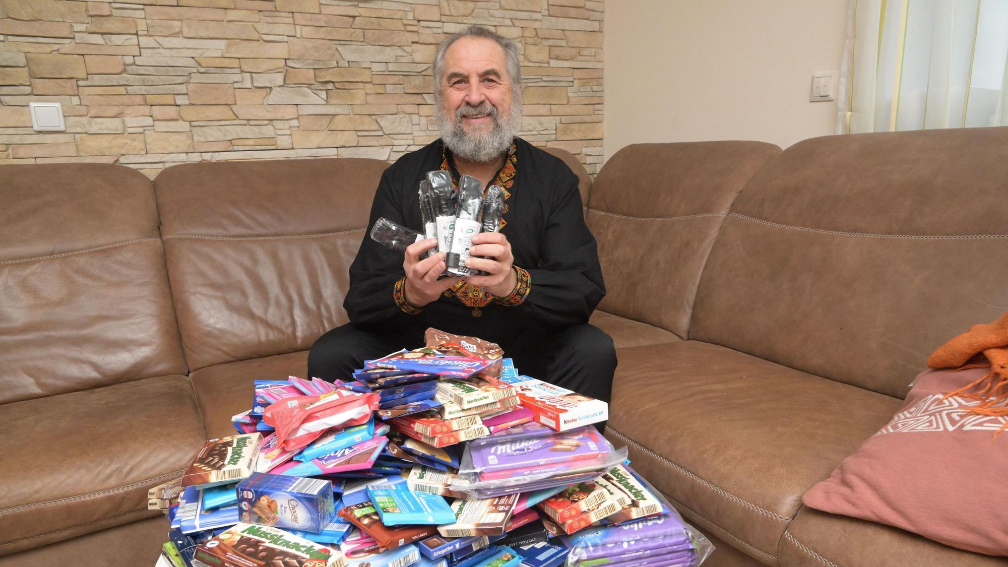Paul Kruk sitzt auf seinem Sofa hinter einem Berg Süßigkeiten.