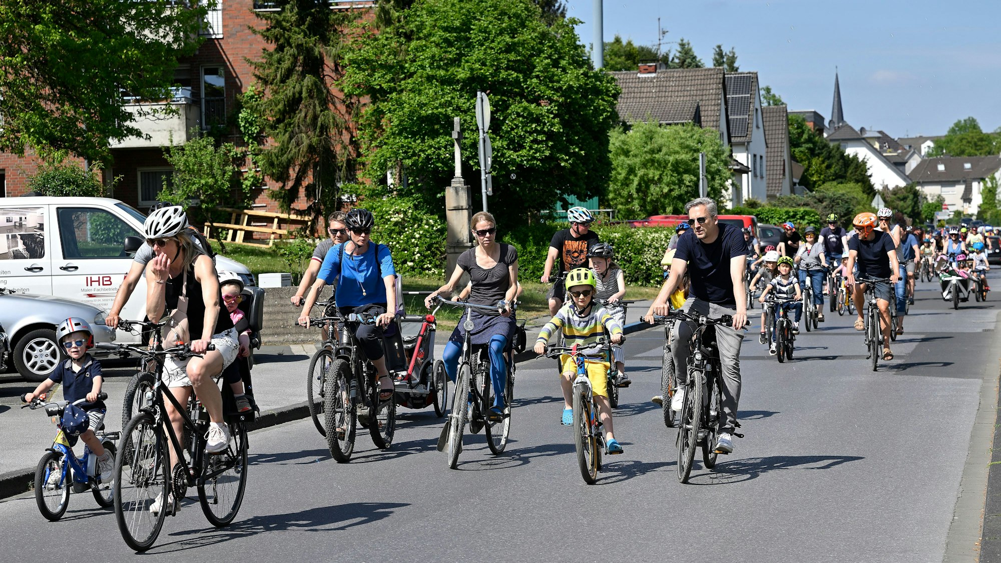 Erwachsene und Kinder fahren für die Demo Kodical Mass Fahrrad auf den Rösrather Straßen.