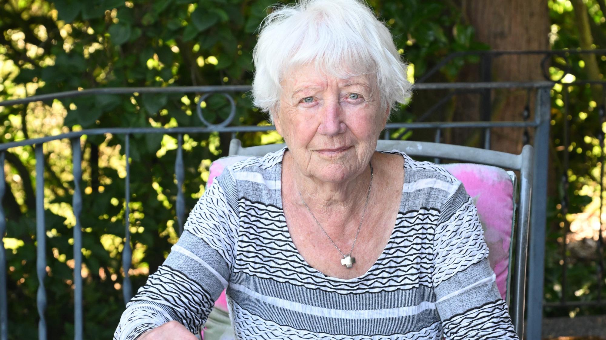 Margot Bäumerich sitzt an ihrem Gartentisch.