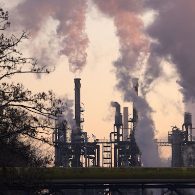 Man sieht eine Industrieanlage, aus Schornsteinen kommt Dampf.