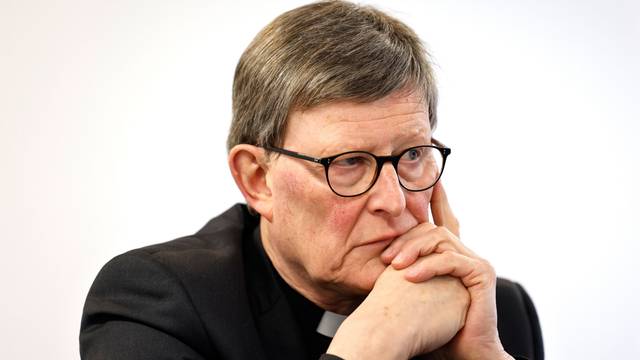 Kardinal Woelki schaut in die Ferne, seinen Kopf auf die Hand gestützt.