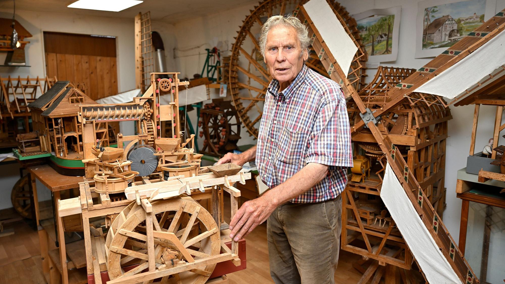 Günter Blömer steht im Museum vor Holzexponaten.