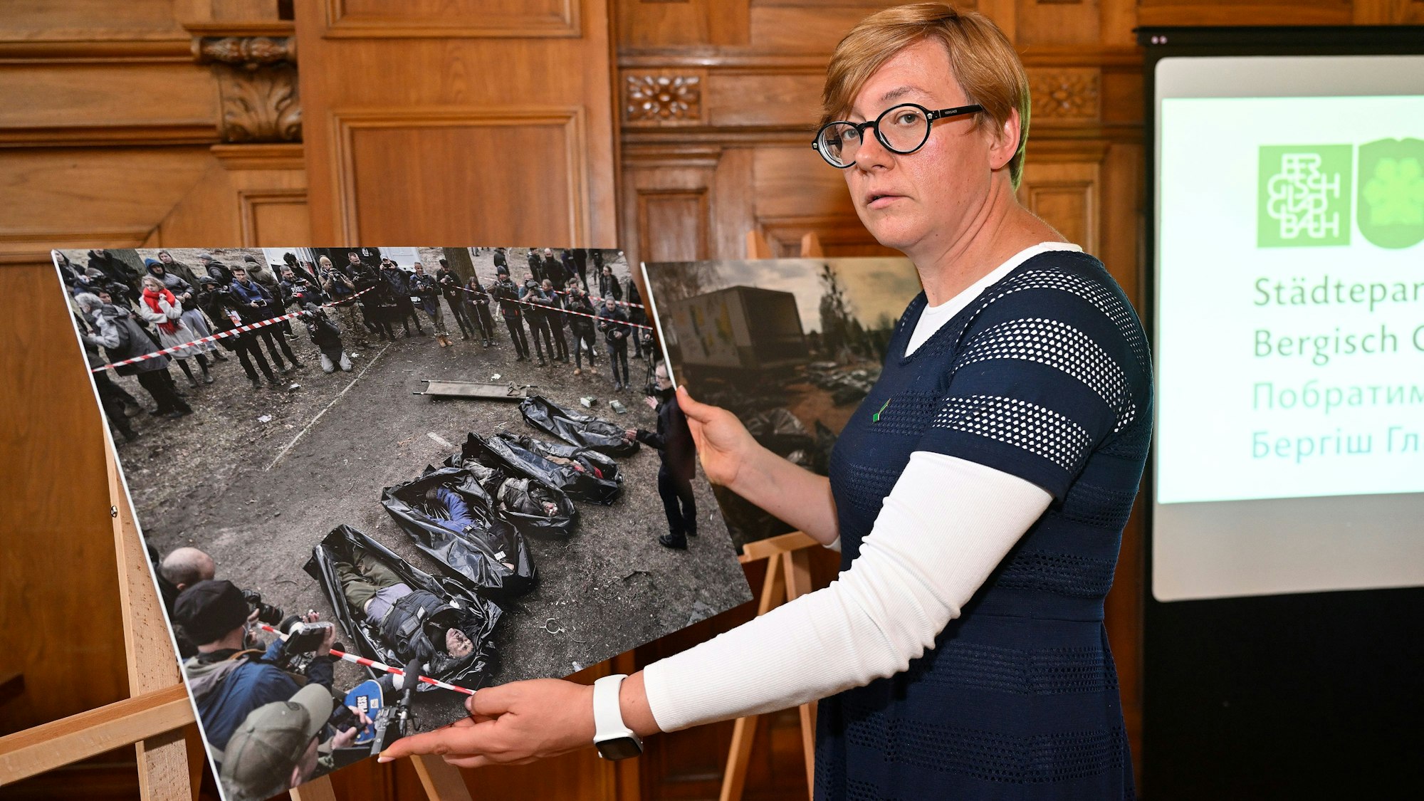 Mykhailyna Skoryk-Shkarivska steht vor einem Foto im Bergisch Gladbacher Rathaus.