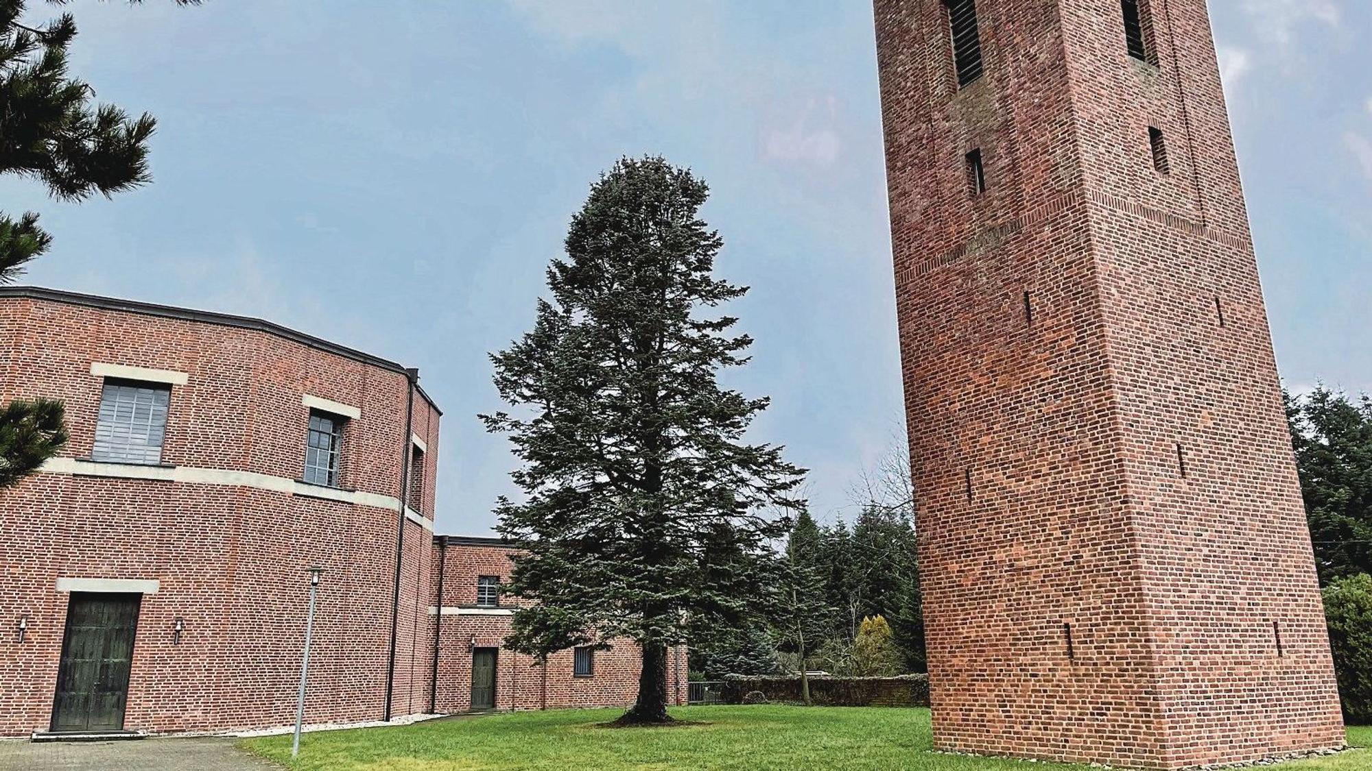 Rechts steht ein hoher, viereckiger Backsteinturm, links ein Rundbau ebenfalls aus Backsteinen. Das Gebäudeensemble liegt in einem kleinen Park, in dem ein hoher Nadelbaum steht.