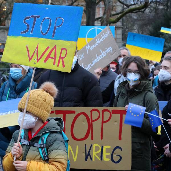 Menschen mit Plakaten auf den "Stop War" und "Stoppt den Krieg" zu lesen ist, stehen bei einer Demonstration gegen den Krieg in der Ukraine auf dem Konrad-Adenauer-Platz in Bergisch Gladbach.