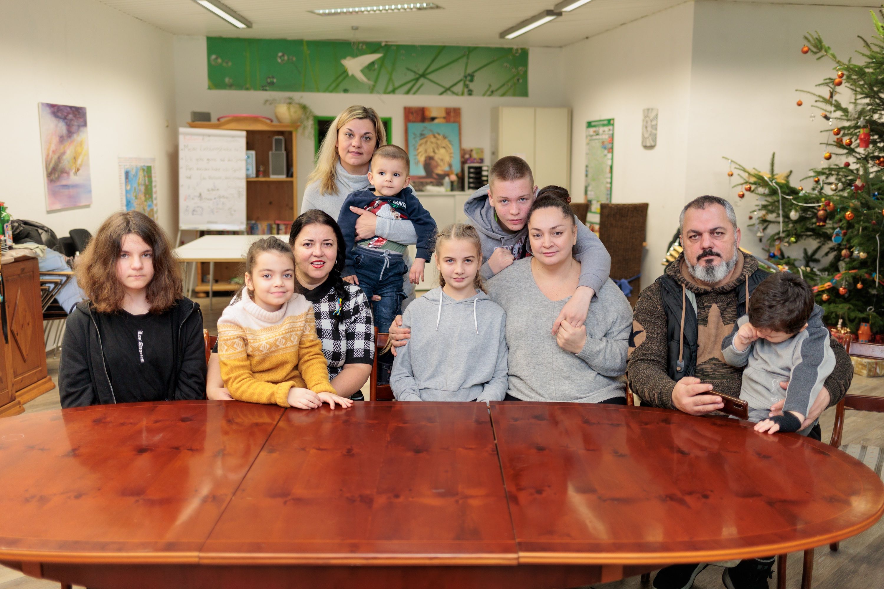 Zwei geflüchtete Familien aus der Ukraine sitzen an einem großen Tisch im Zentrum des Caritas-Verbandes in Gummersbach.