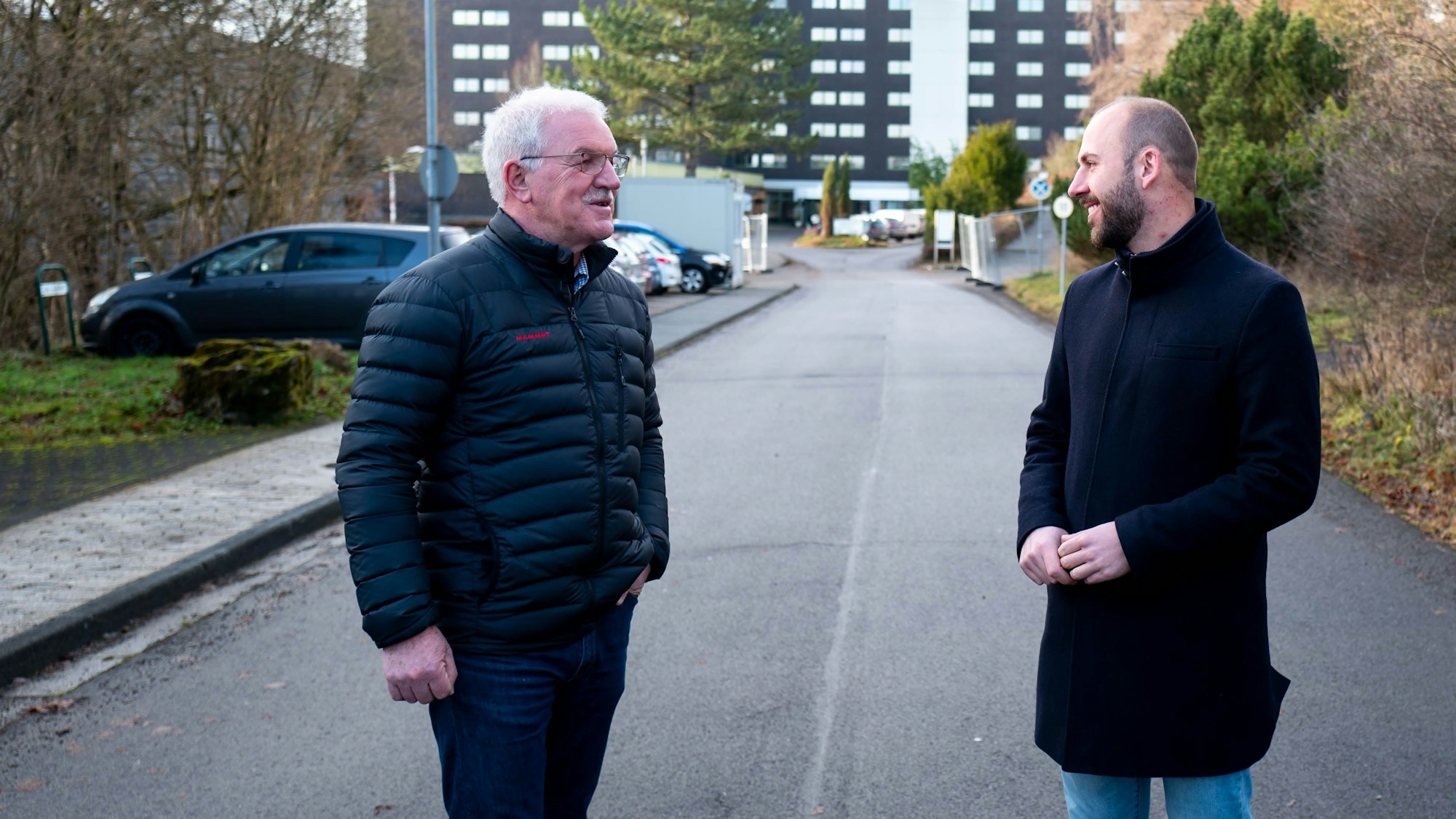 Zwei Männer stehen auf der Zufahrt zur ehemaligen Eifelhöhen-Klinik