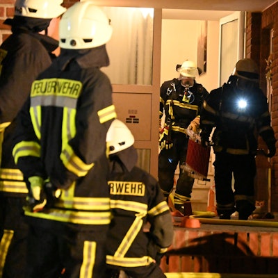 Feuerwehrleute verlassen nach dem geglückten Einsatz ein Wohnhaus. Bei dem Foto handelt es sich um ein Archivbild.