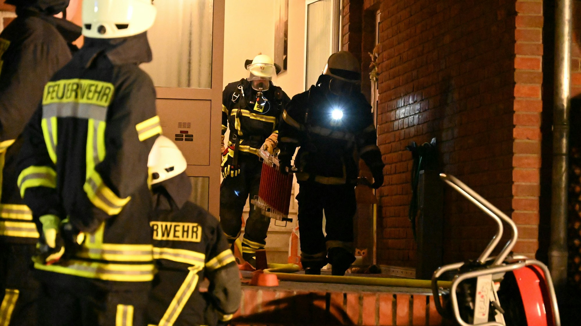 Feuerwehrleute verlassen nach dem geglückten Einsatz ein Wohnhaus. Bei dem Foto handelt es sich um ein Archivbild.