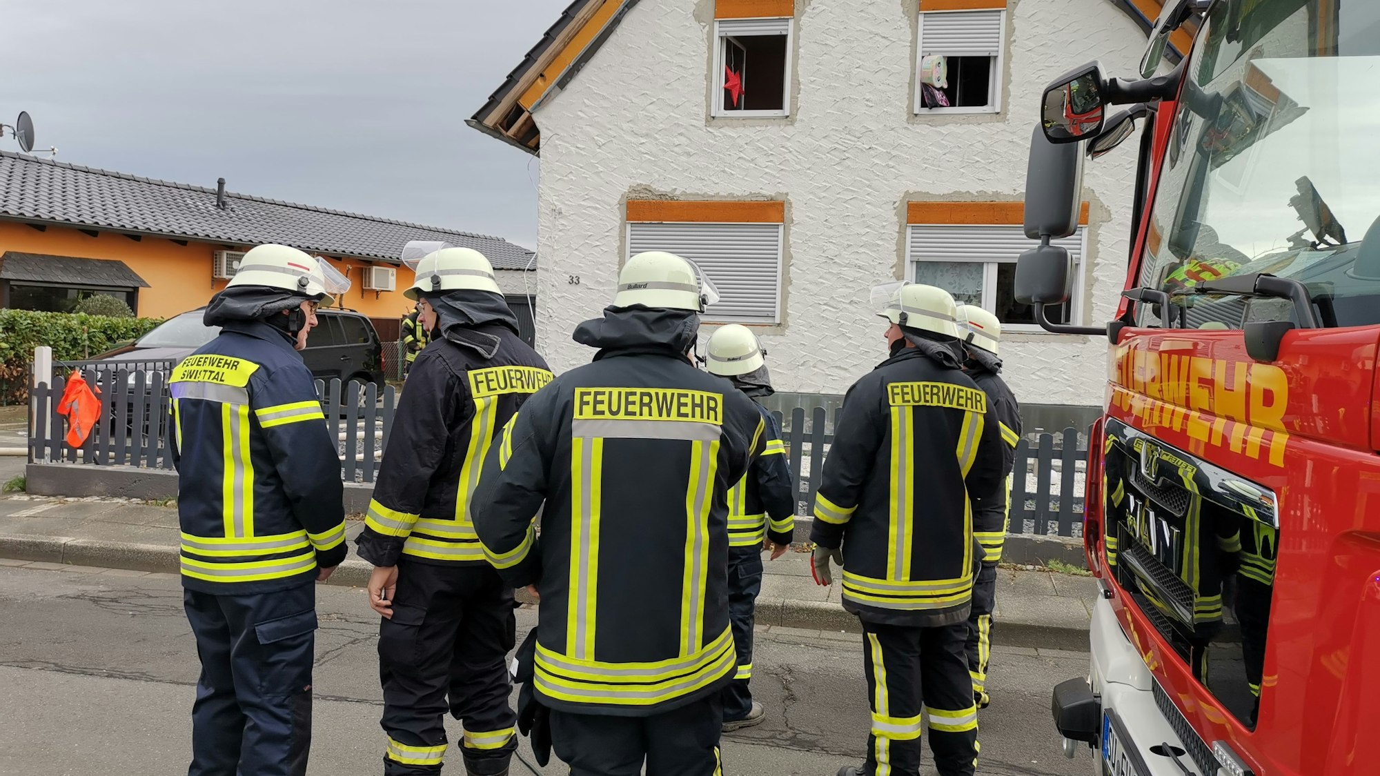 Feuerwehrleute stehen vor einem Haus in Buschhoven, in dem es ein Feuer gegeben hatte