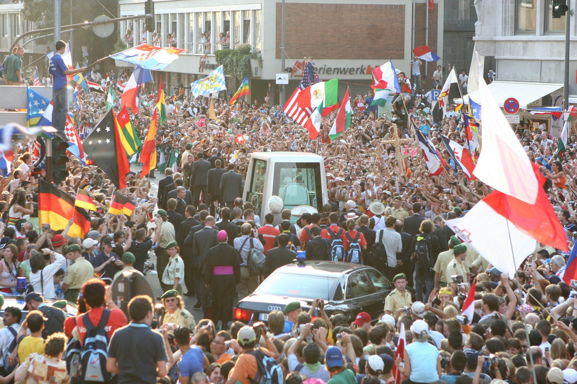 Das Papamobil zwischen Menschenmassen in der Kölner City.
