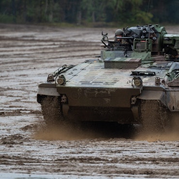 Ein Schützenpanzer der Bundeswehr fährt bei einer Informationslehrübung über einen Übungsplatz.
