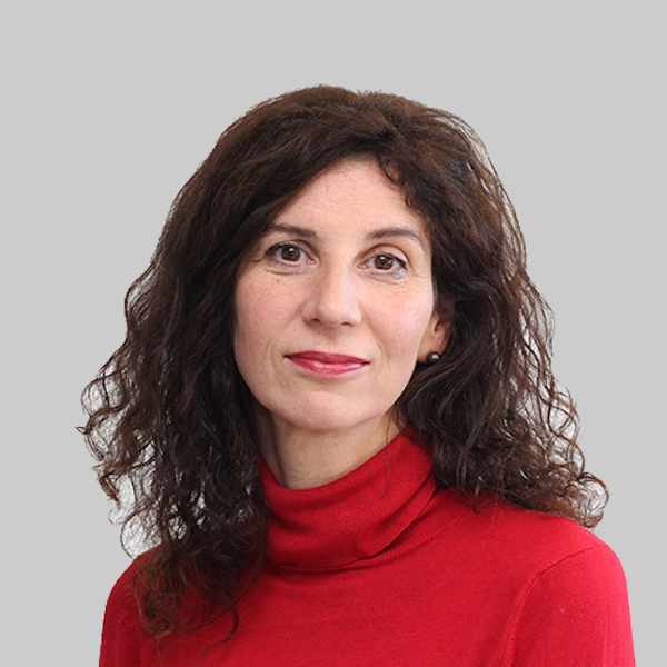 Ein Geistlicher in schwarzem Anorak steht in einer voll besetzten Kirche und spricht in ein Mikrofon, eine Frau sitzt daneben.