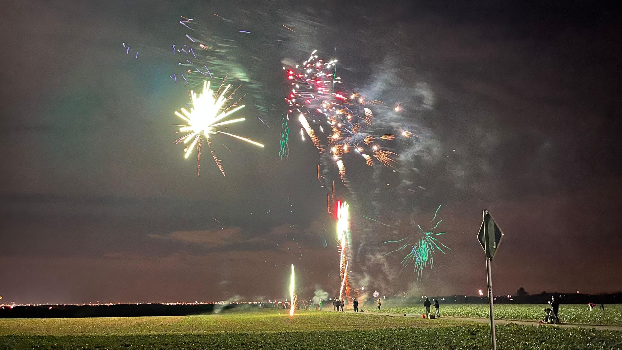 Feuerwerk über freiem Feld bei Nacht.