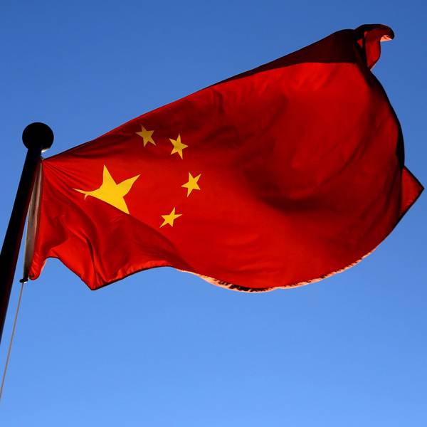 Die Fahne Chinas weht vor einem strahlend blauen Himmel.