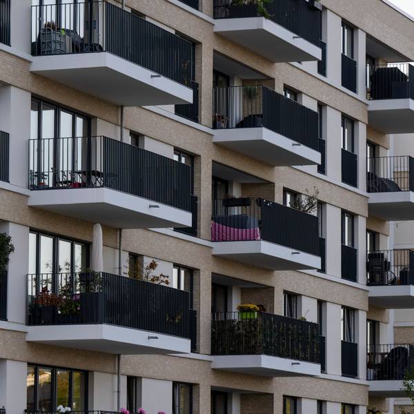 Zu sehen sind mehrere neu gebaute Wohnhäuser, deren Balkone dicht aneinander liegen.