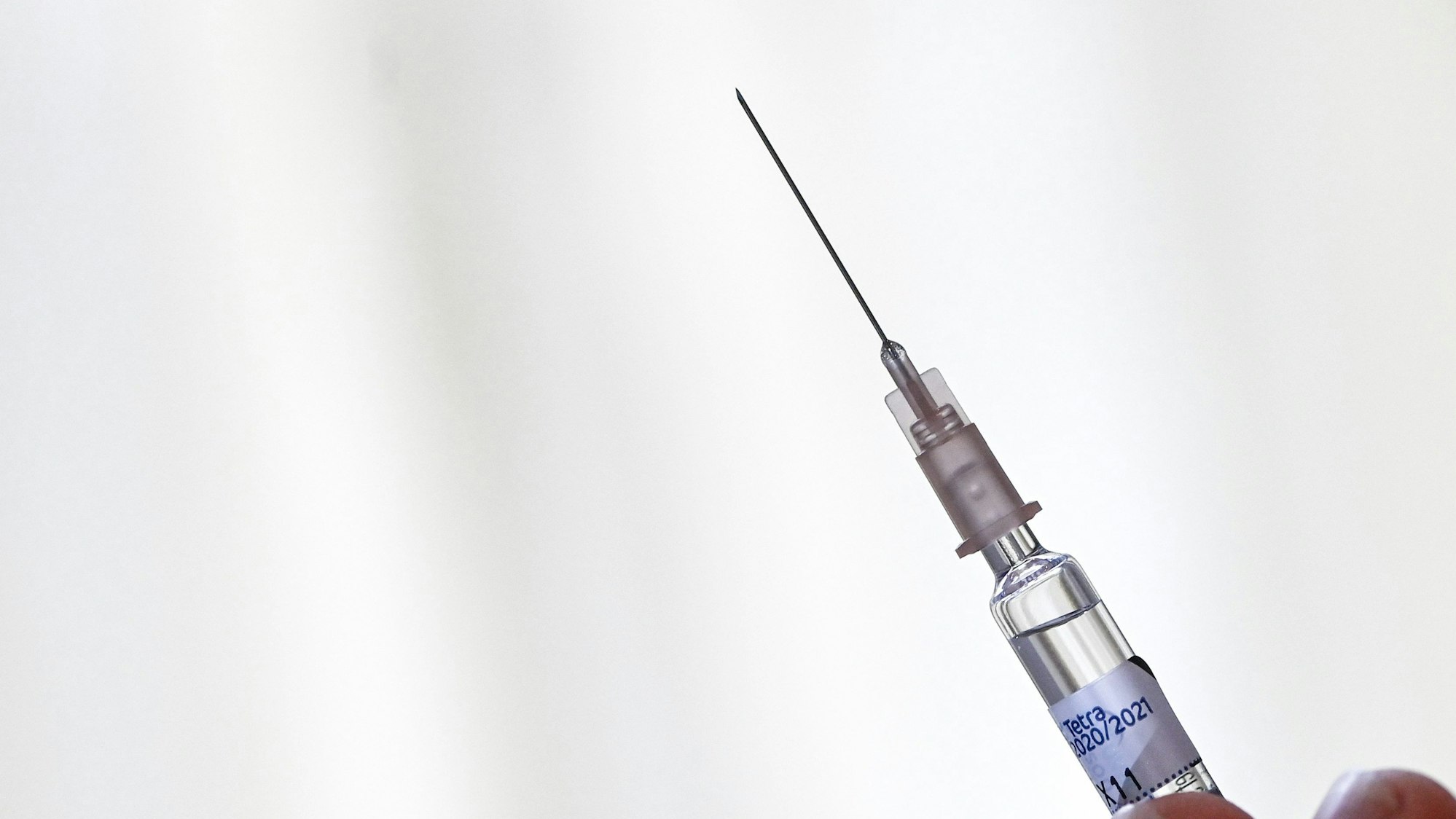 Ein Arzt hält eine Spritze mit einer Grippeimpfung in der Hand.