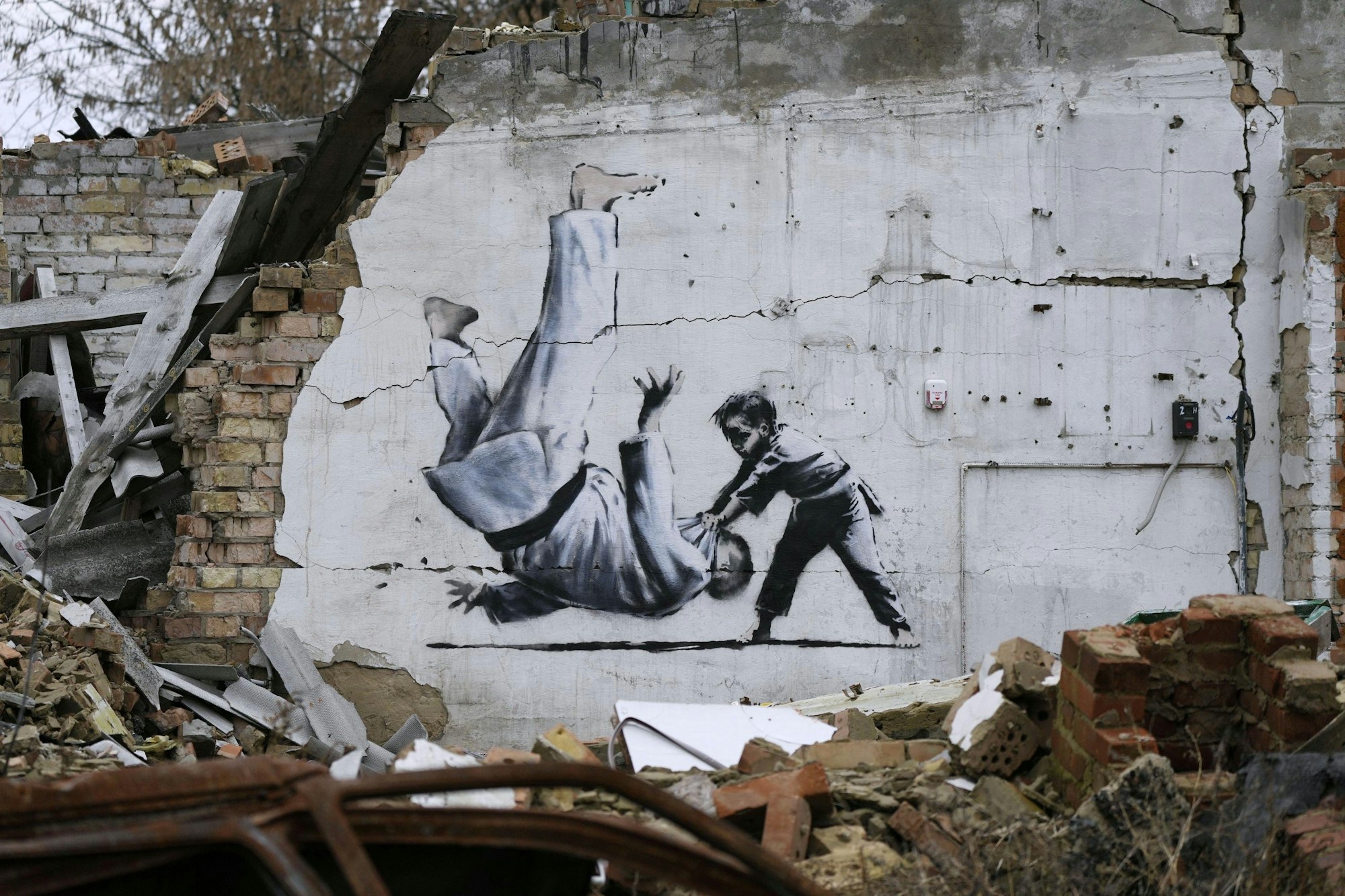 Ein Kunstwerk, das vermutlich von dem bekannten Graffitikünstler Banksy stammt, an einem beschädigten Gebäude in der Nähe von Kiew.