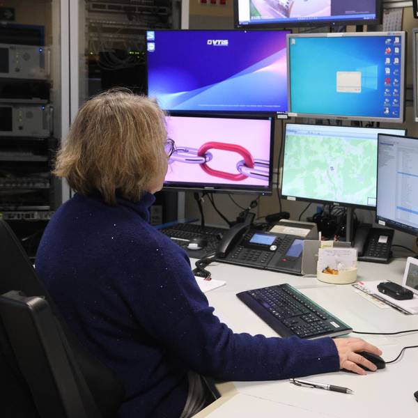 Claudia Waltereit in der Leitstelle vor zahlreichen Monitoren und technischem Gerät.