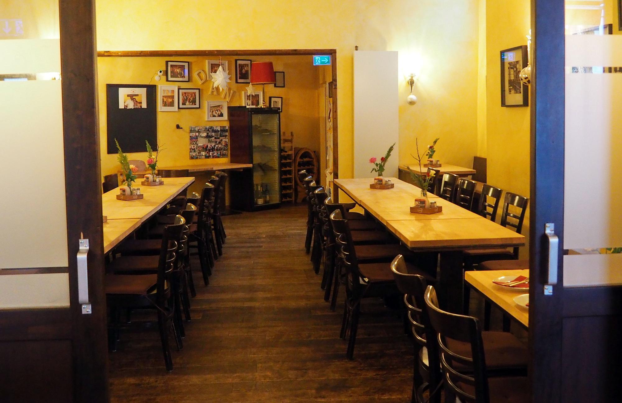 Ein Raum im Lokal mit langen Tischreihen und Stühlen.