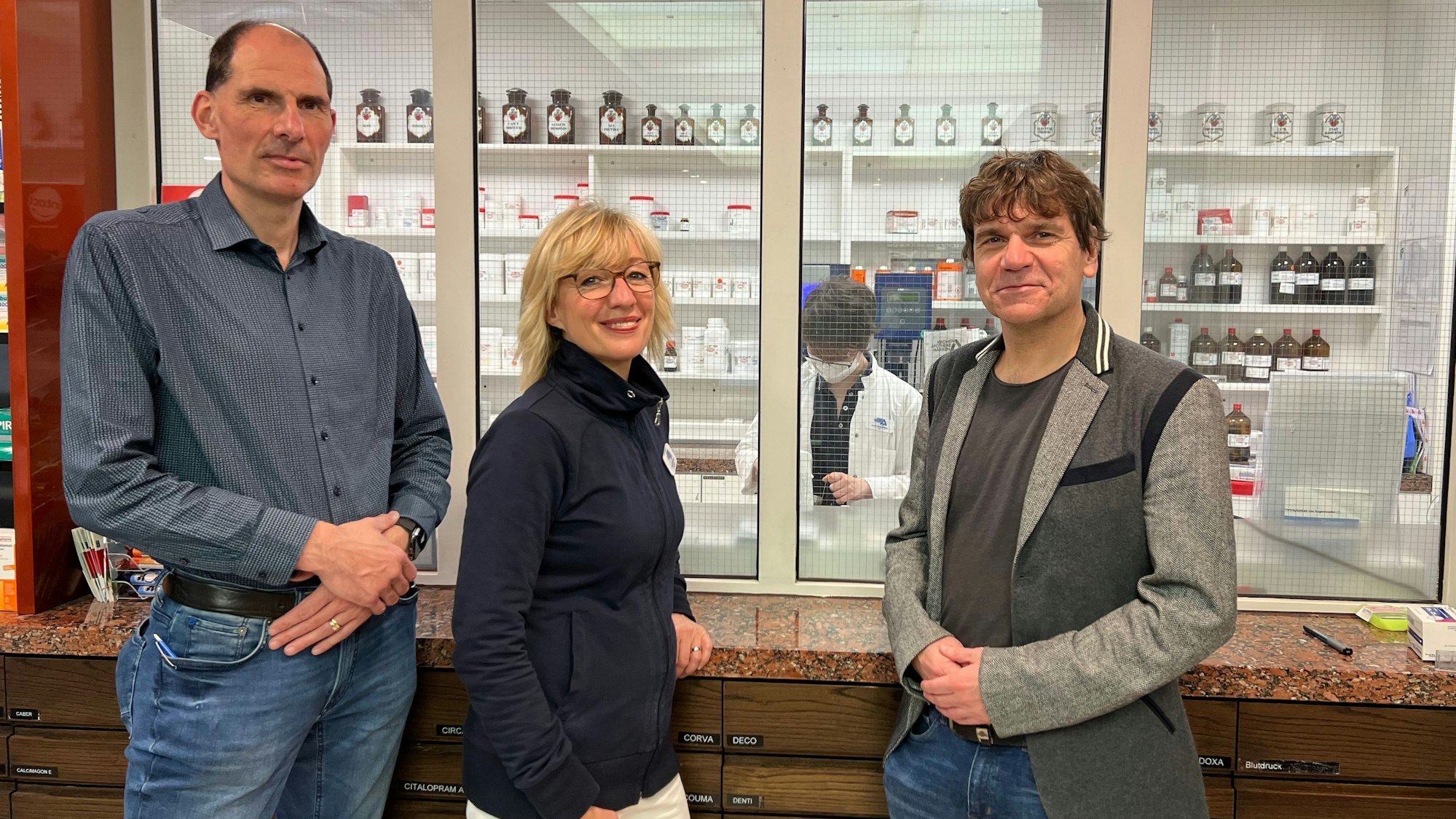 Die drei vor der Küche mit zahlreichen Apothekerfläschchen im Hintergrund.