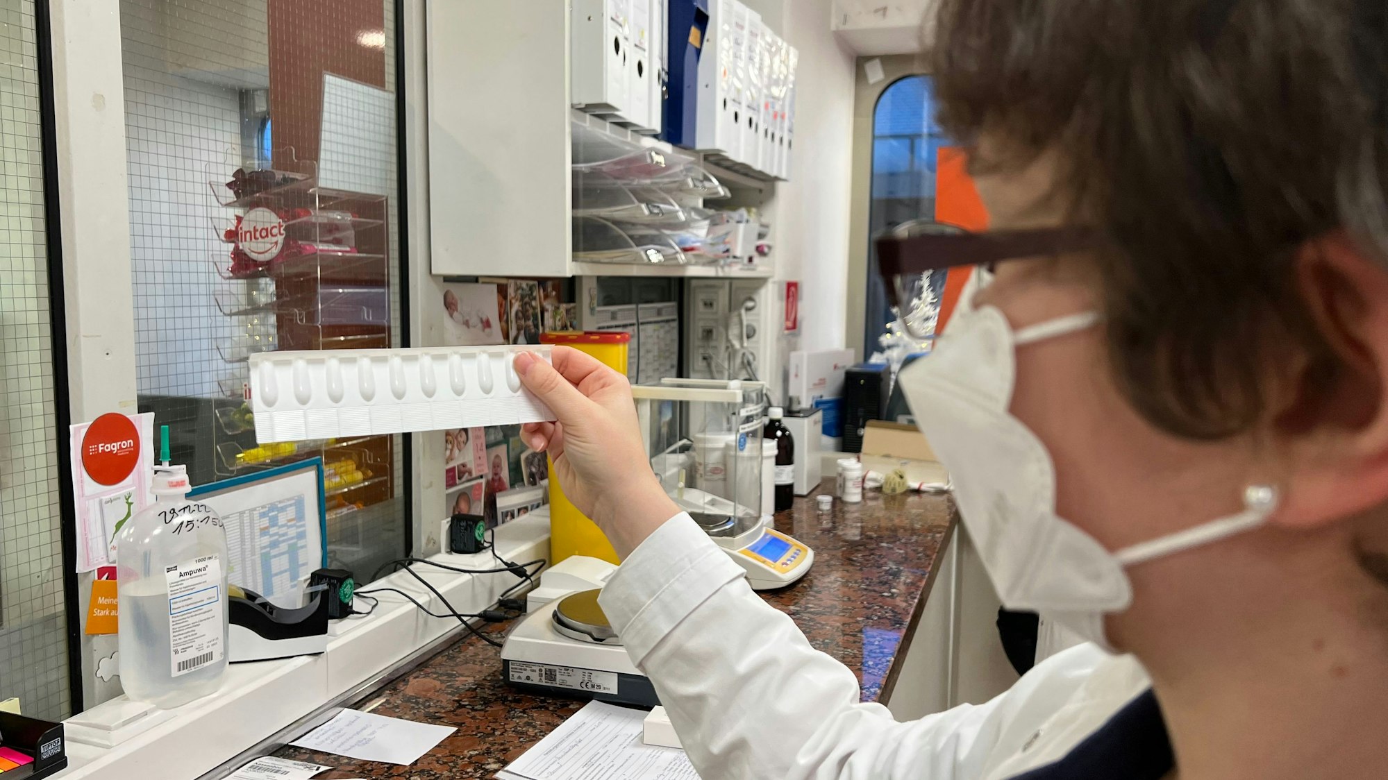 Hofenbitzer hält die Tablettenform hoch in der Arzneiküche.