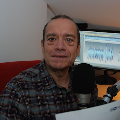 Kaiser vor Mikrofon und Bildschirm in einer Schräge.