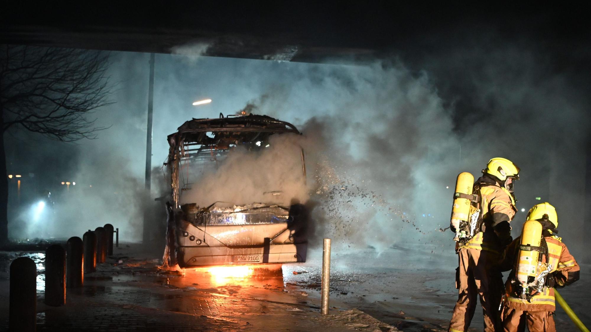 Berlin: Feuerwehrmänner löschen an der Sonnenallee einen Reisebus, der von Unbekannten angezündet worden war.