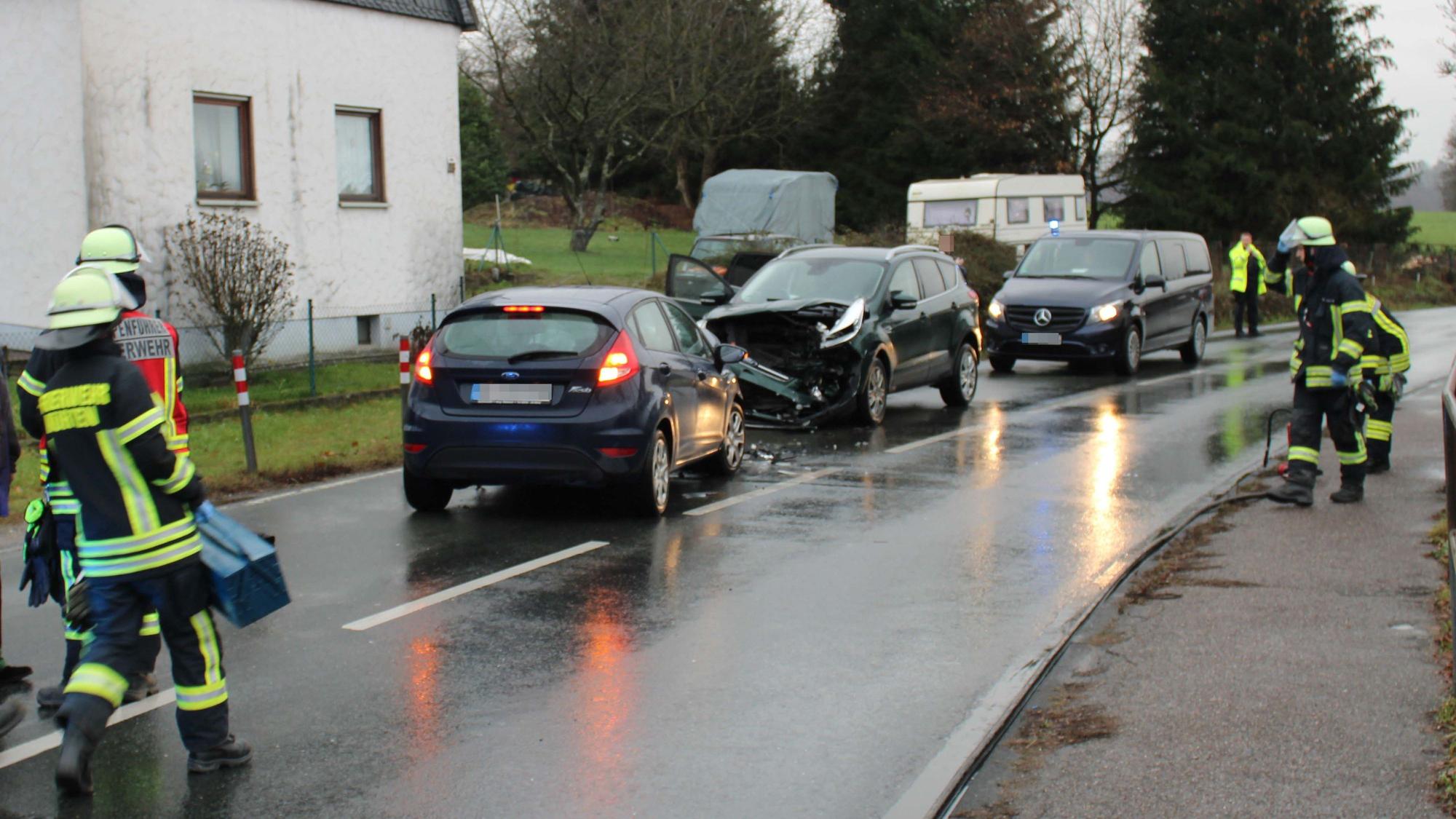 Zwei Autos sind frontal zusammengestoßen. Bei einem ist ein Totalschaden vorne zu sehen. Feuerwehrkräfte sind an der Einsatzstelle.