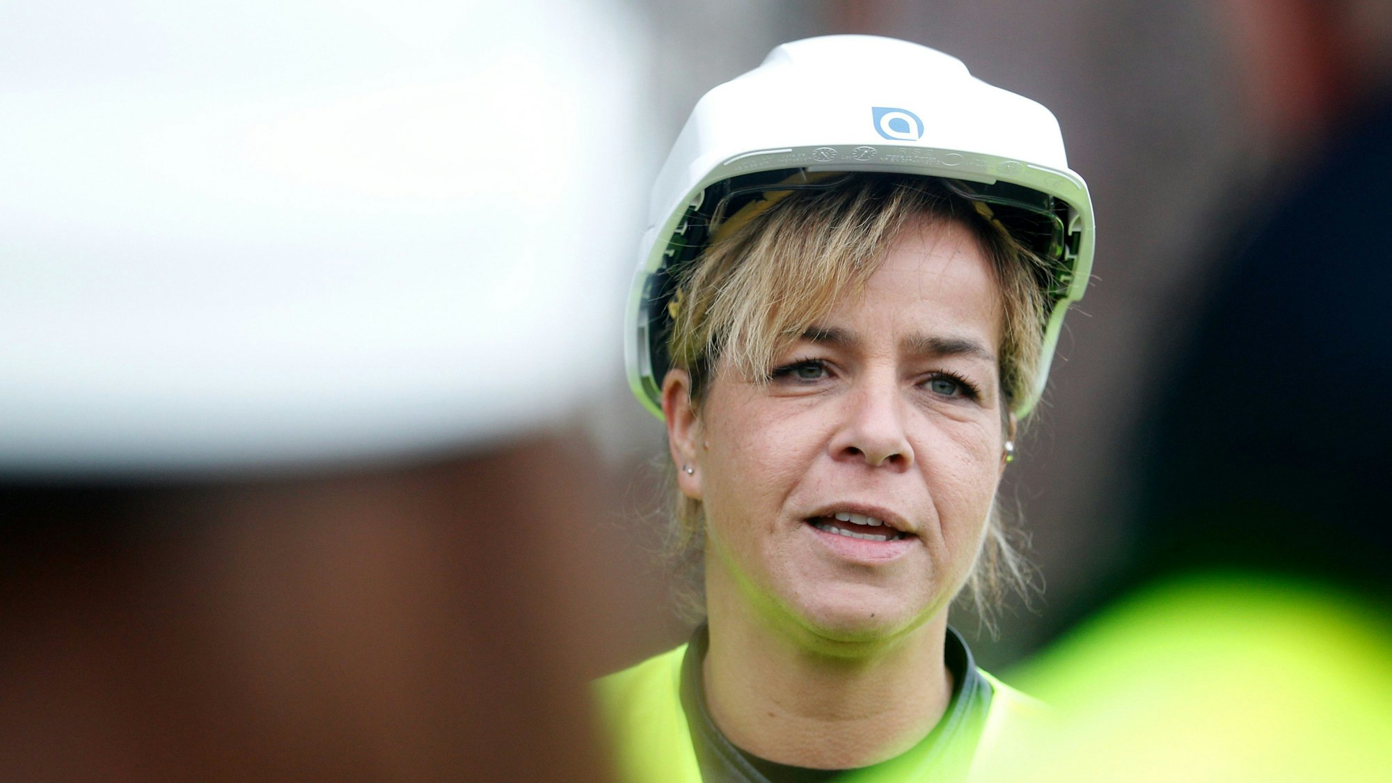 Mona Neubaur trägt einen Sicherheitshelm und eine Warnweste.