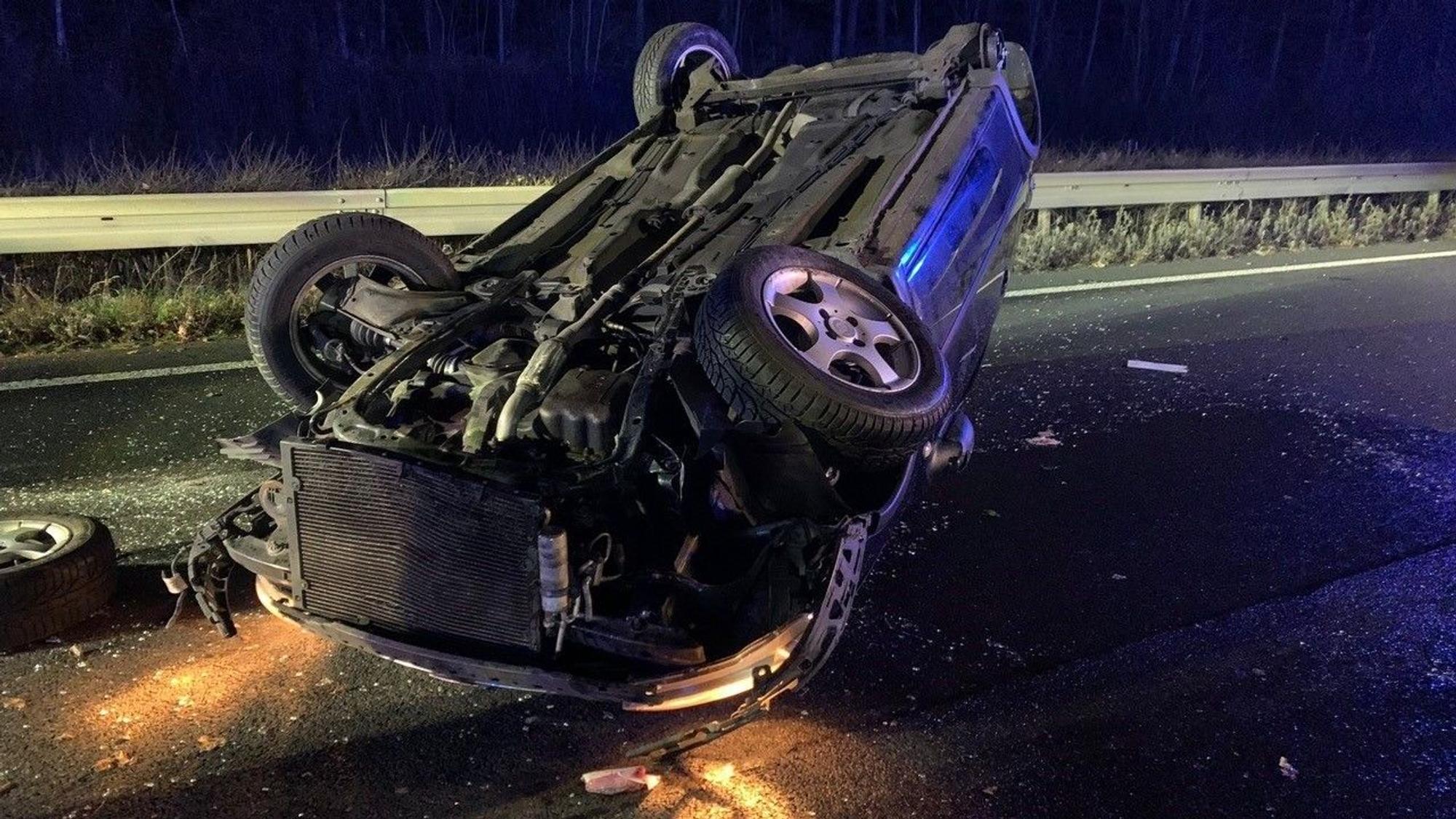 Ein Auto liegt schwer beschädigt auf dem Dach.