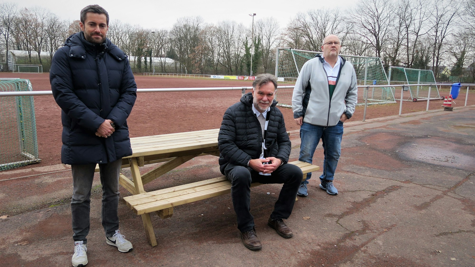 Daniel Rettig, Hans-Georg Offermann und Wolfgang Müller vor einem Ascheplatz.