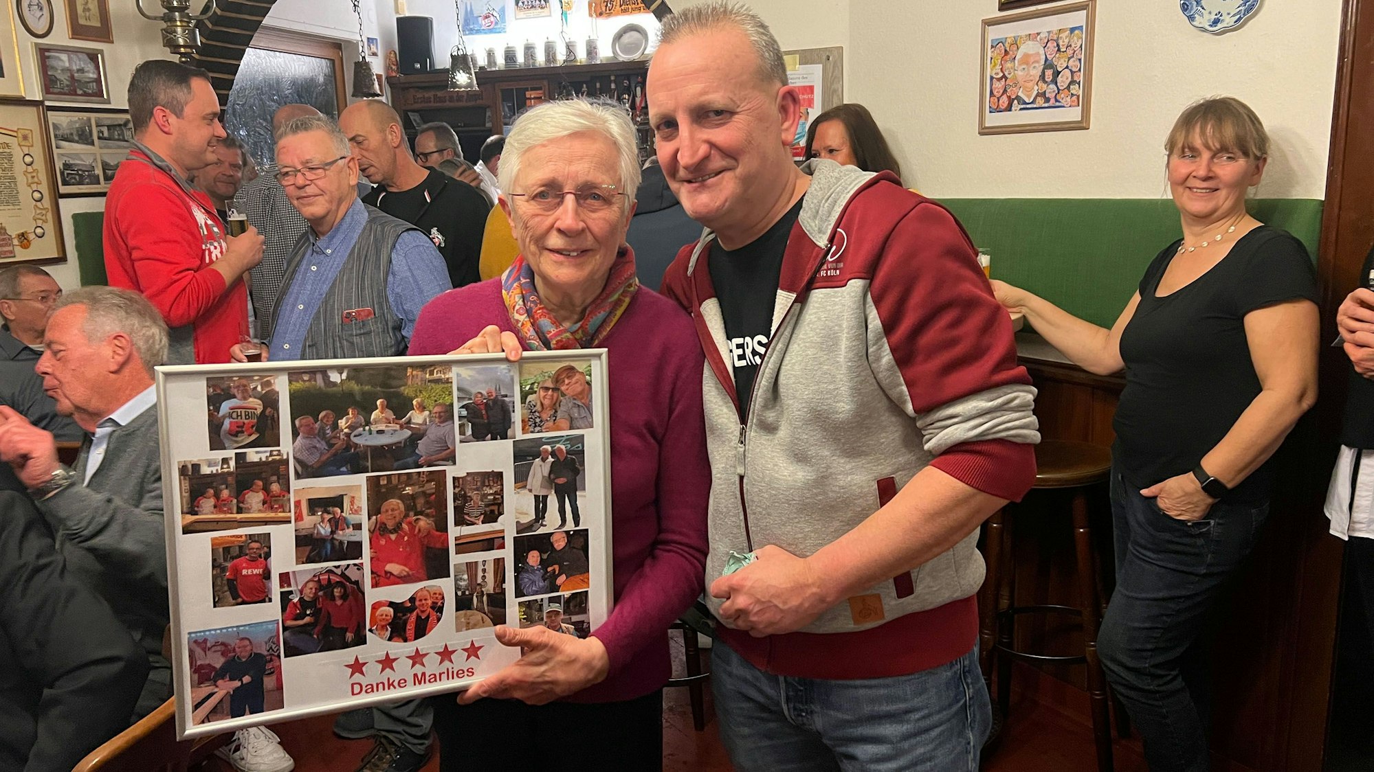 Michael Pütz vom FC-Fanclub Hemmersbach, hier im Januar 2023, überreicht eine Fotocollage an Marlies Wolter.