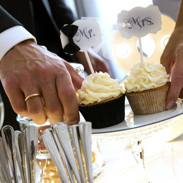 Ein Ehepaar hält zwei Muffins, auf denen steht „Mr. und Mrs.“.