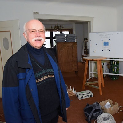 Anke Bockelmann und Georg-Wilhelm Overbeck stehen in einem der renovierungsbedürftigen Räume des Pfarrhauses in Marienheide-Müllenbach. Im Hintergrund sind weggerückte Schränke und gepackte Kartons zu sehen.