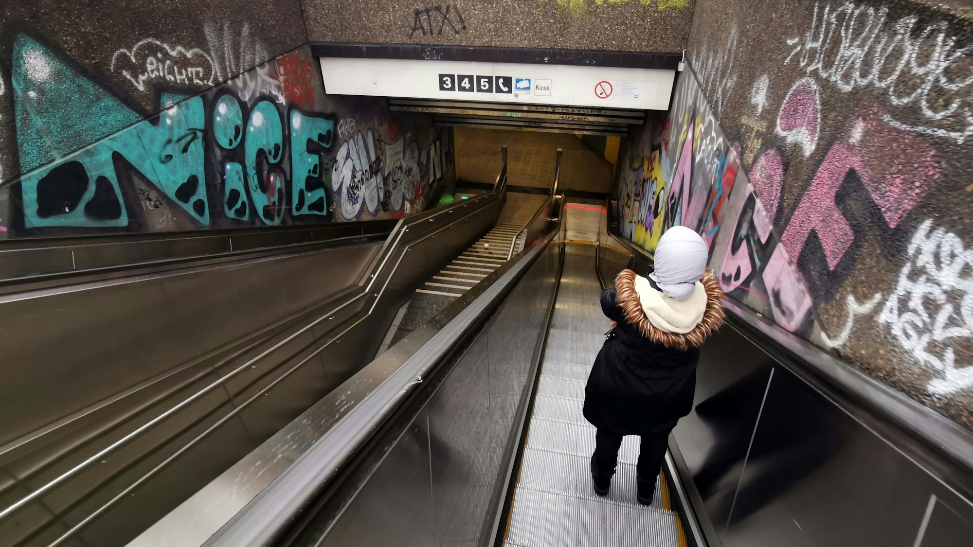 Eine Person fährt auf der Rolltreppe runter zur U-Bahn-Haltestelle Hans-Böckler-Platz/Bahnhof West.
