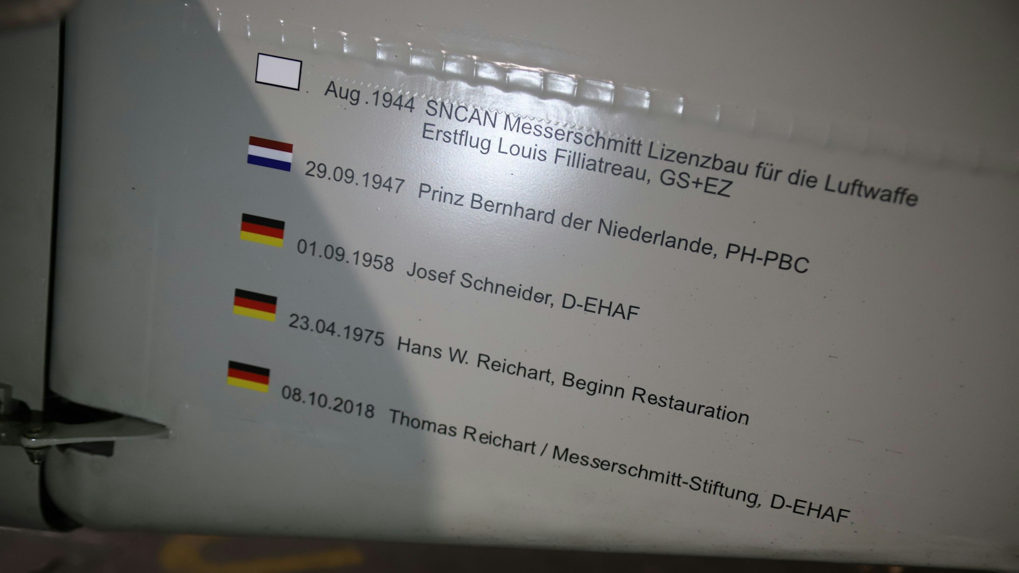 Auf dem Rumpf der Maschine stehen Daten mit Namen und Flaggen.