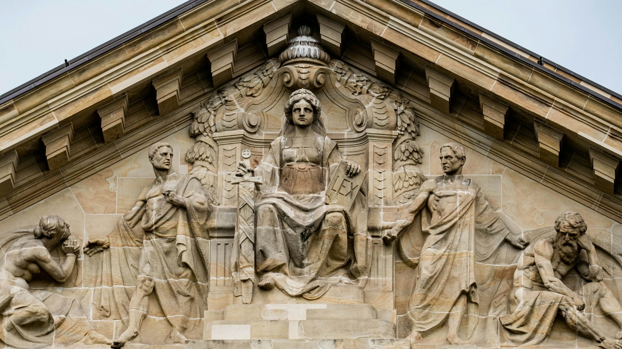 Die römische Göttin Justitia mit Schwert und Gesetzesbuch – aber ohne Augenbinde.