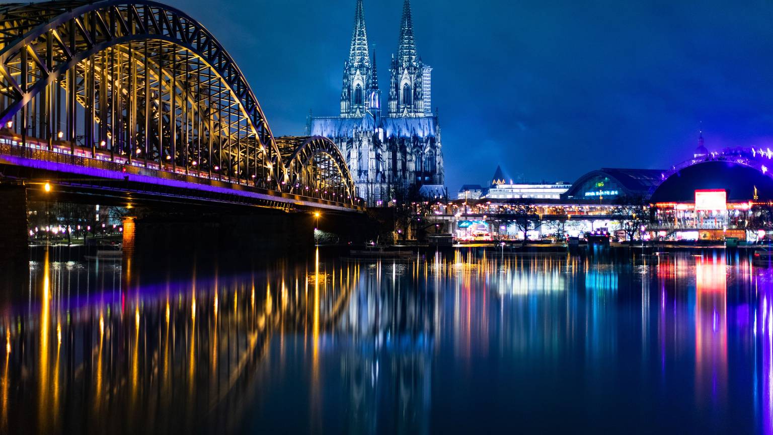 Nächtliches Panorama von Köln mit Hohenzollernbrücke, Dom, Hauptbahnhof und Musical Dome.