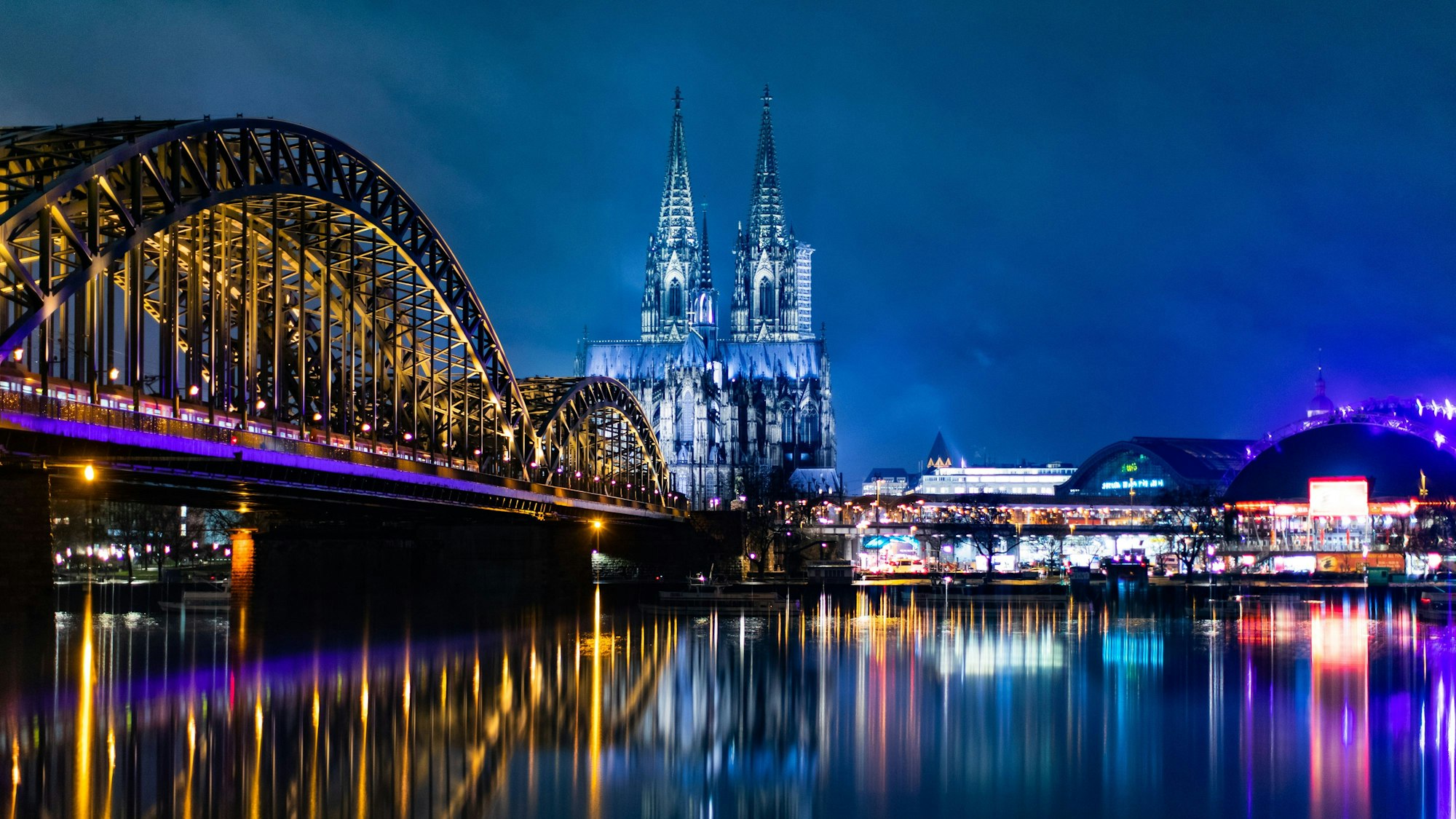 Nächtliches Panorama von Köln mit Hohenzollernbrücke, Dom, Hauptbahnhof und Musical Dome.