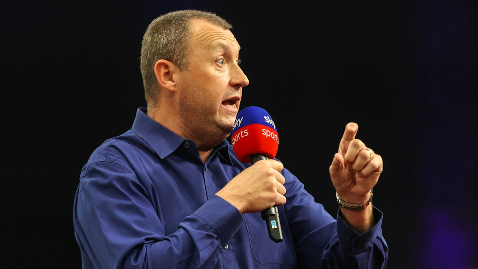 Sky-Kommentator Wayne Mardle hält ein Mikro in der Hand.
