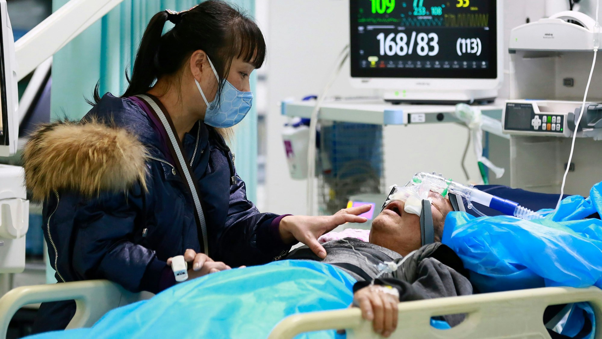 31.12.2022, China, Suining: Eine Frau kümmert sich um einen Angehörigen in einem Krankenhaus.