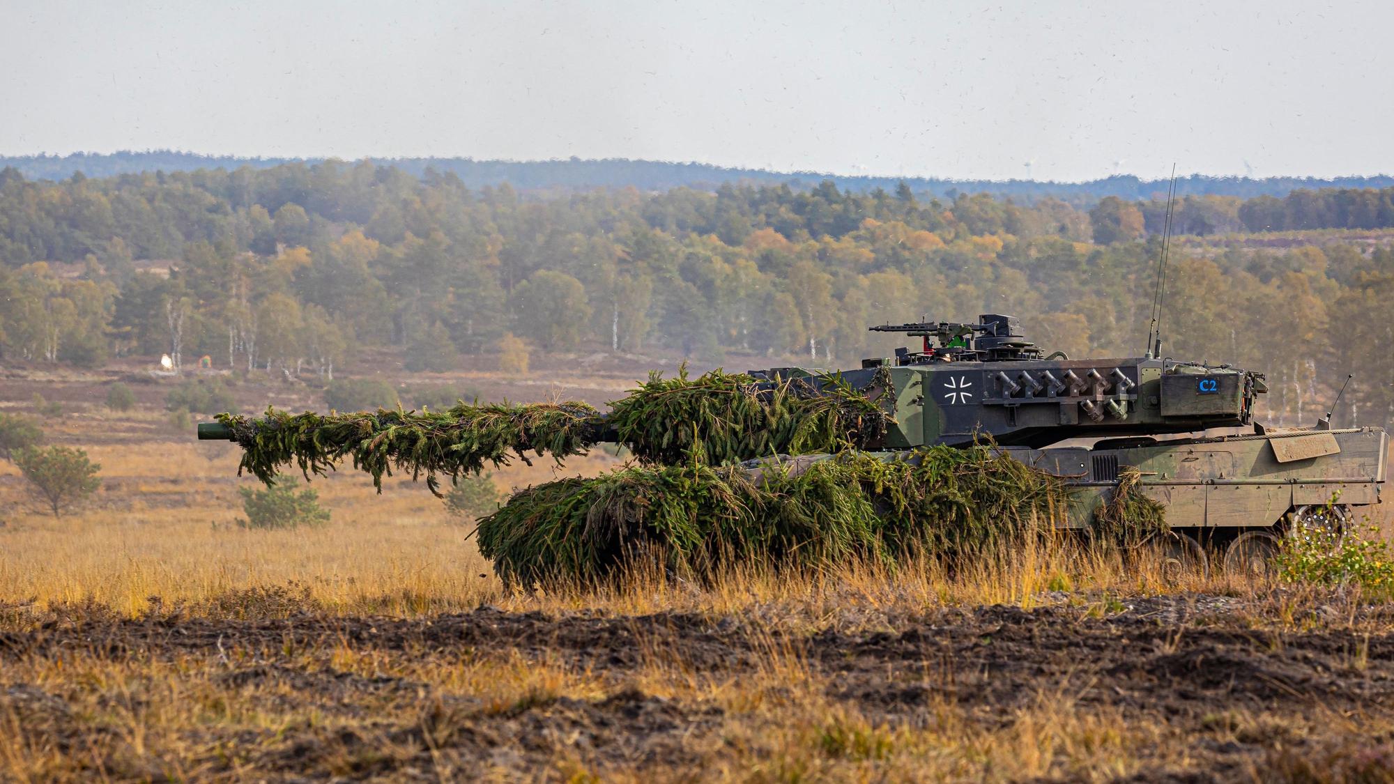 Ein Kampfpanzer Leopard 2 fährt auf einem Feld.