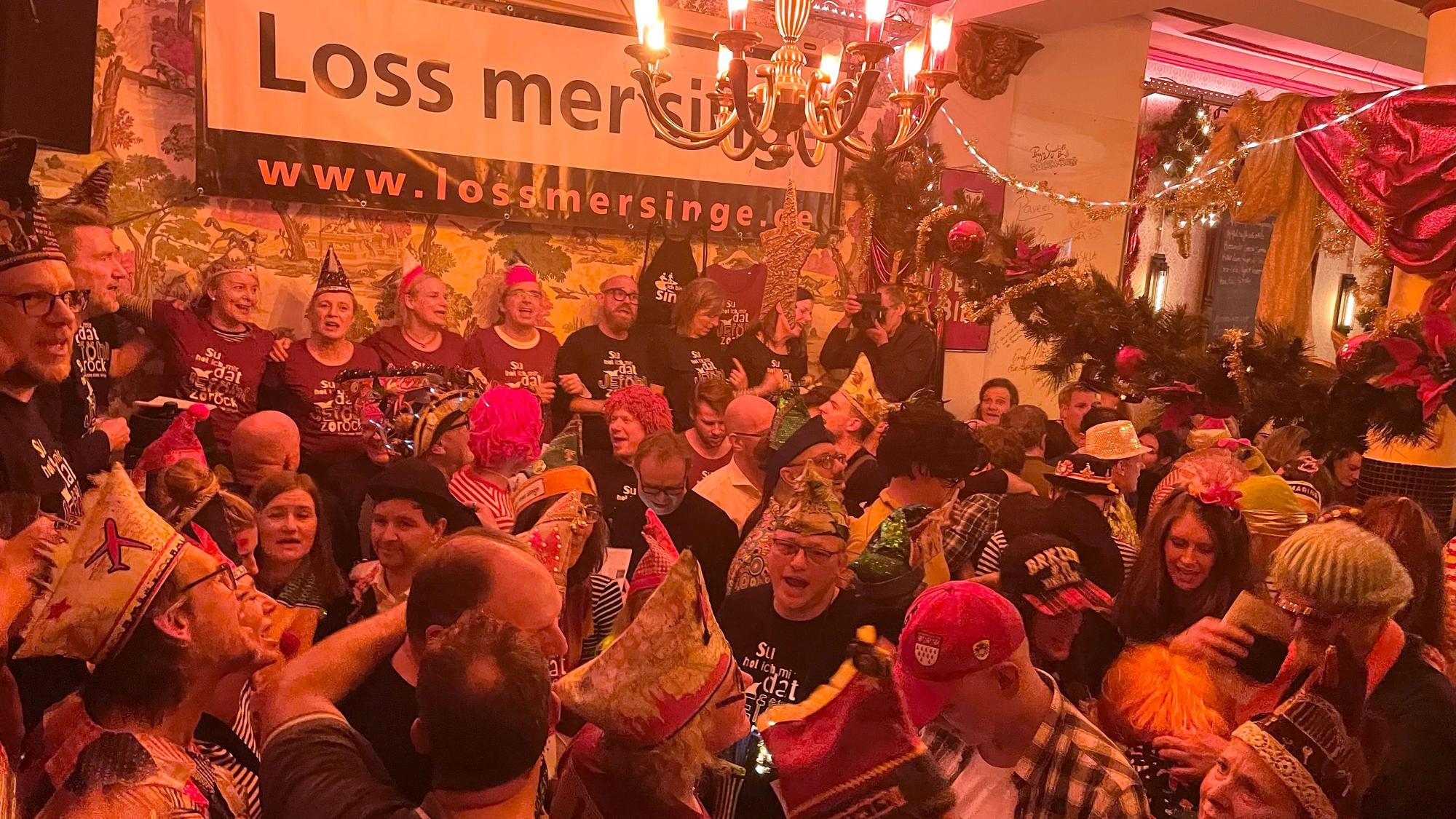 In der Kölner Kneipe Lapidarium am Eigelstein stehen viele Menschen eng aneinander gedrengt und singen die Neuerscheinungen der aktuellen Karnevals-Session.